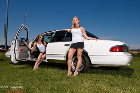 1997 Mercury Grand Marquis - A white 1997 Mercury Grand Marquis is shown with two women posing in and around it on a grassy field.