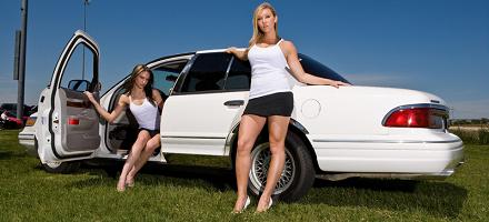 1997 Mercury Grand Marquis - A white 1997 Mercury Grand Marquis is shown with two women posing next to it on a grassy field.