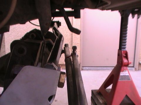 1997 Ford Ranger - A vehicle's suspension part is shown, supported by a red jack stand, with visible text on the stand.