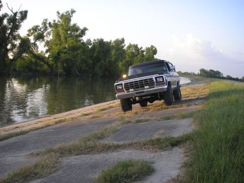 1979 Ford Bronco - Black 1978 Ford Bronco driving on a levee beside a body of water.