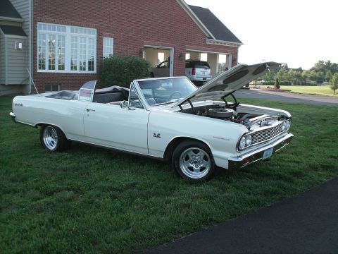 1970 Ford Mustang - A white 1964 Chevrolet Chevelle Malibu convertible sits on a lawn with its hood open, revealing the engine.