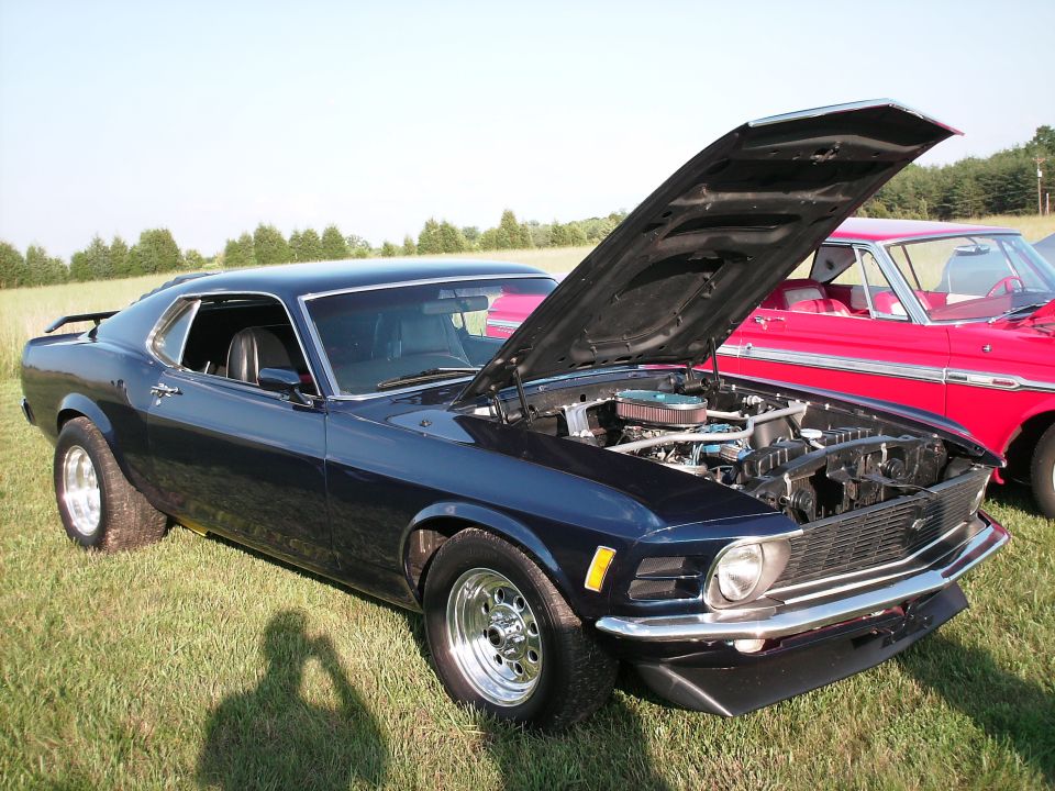 Dark blue 1970 Ford Mustang coupe with hood open, parked on grass