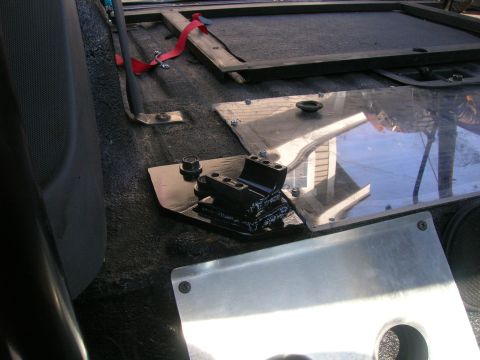 1996 Ford Bronco - The interior of a vehicle shows custom seat mounting hardware installed on the floor.