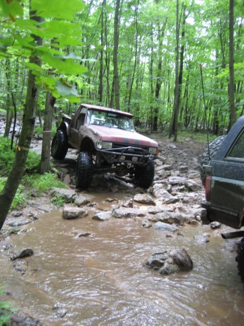 1991 Ford Bronco - An off-road truck navigates a challenging rocky stream during a spring ride event.