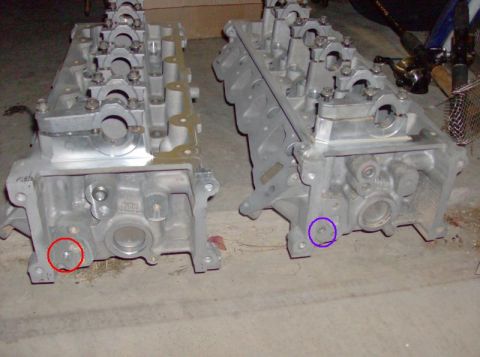 2000 Mercury Grand Marquis - Two engine cylinder heads are displayed on a concrete surface, possibly for repair or replacement.