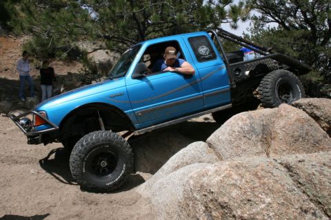 1993 Ford Bronco - This modified pickup truck navigates a rocky trail, its off-road capabilities.