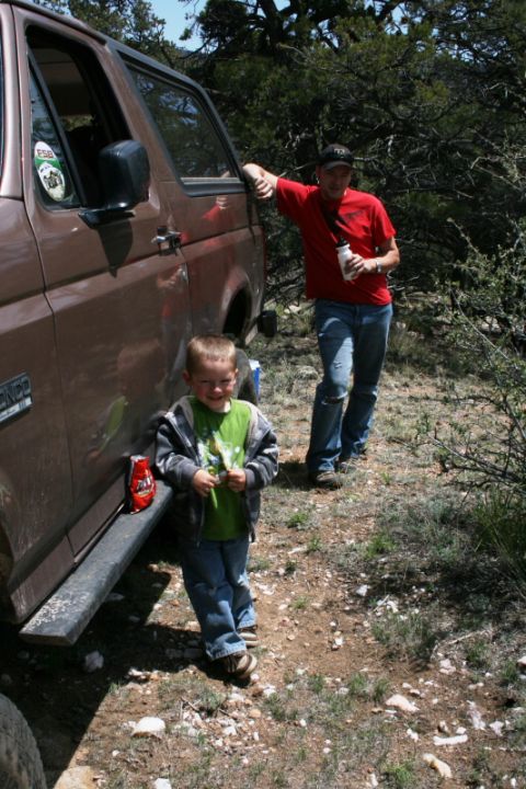 1993 Ford Bronco - A man and a child stand next to a 1993 Ford Bronco in an outdoor, wooded area.