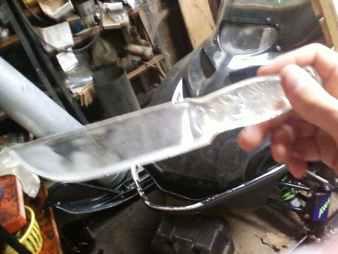1990 Ford Bronco - A clear knife is held up in front of a cluttered background.