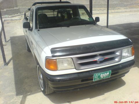 1992 Ford Crown Victoria - This white Ford Ranger pickup truck is parked outdoors under a covered area, showing its front grille and bumper.