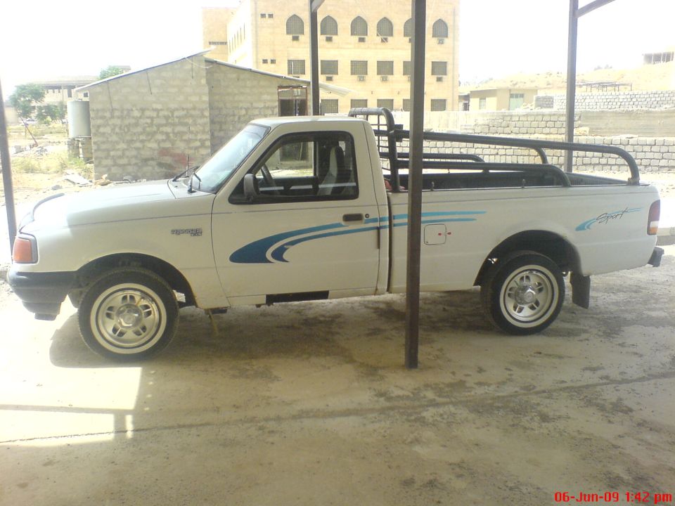 White Ford Ranger pickup truck, side view, with blue graphics on doors and bed