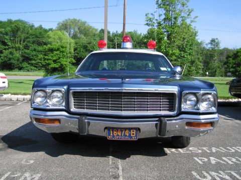 1991 Ford LTD Crown Victoria - Front view of a dark blue vintage police sedan with three red roof beacons and a yellow NY OFFICIAL plate 18474-B.