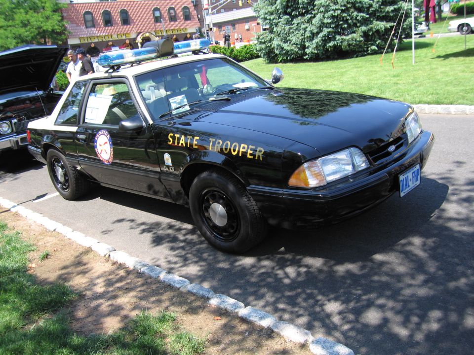 Front three-quarter of black State Trooper Mustang coupe with roof lightbar