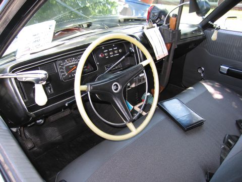 1991 Ford LTD Crown Victoria - interior of a vintage car showing a cream-colored steering wheel, dashboard gauges and bench seat.