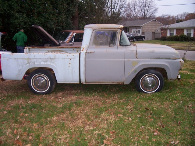 White vintage 1950s-60s Ford pickup parked on grass