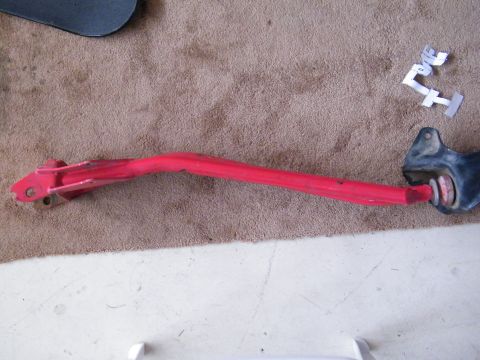 1982 Ford Bronco - A red suspension component is shown resting on a carpeted surface.