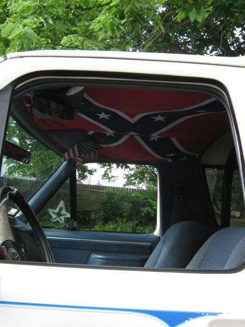 1987 Ford Bronco - Interior view of a vehicle a Confederate flag on the headliner and an American flag accent.