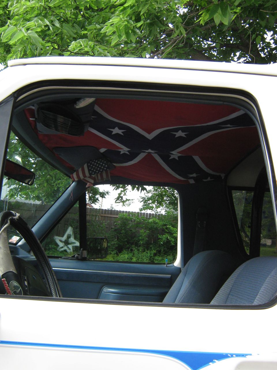 Interior view of a vehicle with a Confederate flag headliner and American flag accent