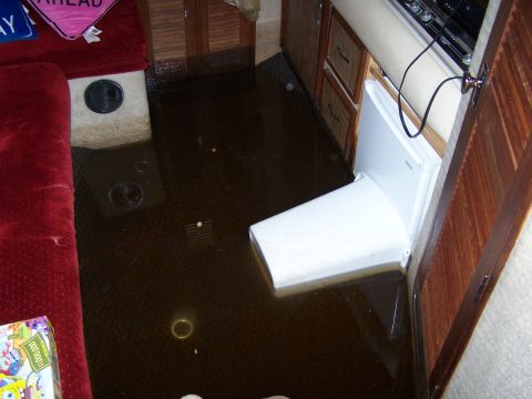1979 Ford F-150 - The interior of a recreational vehicle is submerged in dark water, indicating a significant leak or flood event.