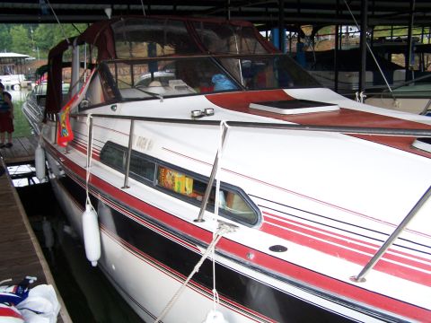 1979 Ford F-150 - A white and red boat is moored at a dock under a covered structure.