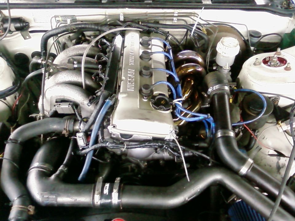 1991 Nissan 240SX engine bay with SR20DET engine, turbo manifold, and intake piping