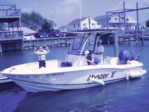 1979 Ford F-250 - A boat named 'Myster E' is docked with people on board and a child standing on the deck.