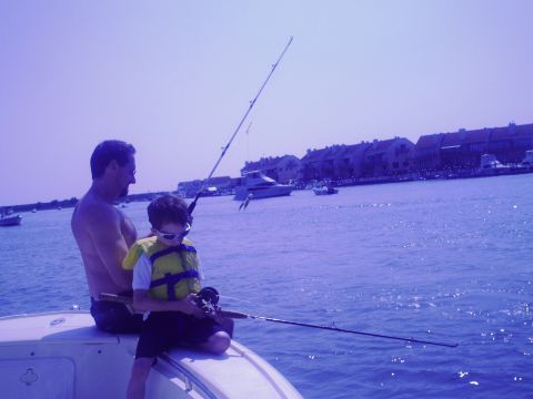 1979 Ford F-250 - Father and son enjoy a day of fishing on the water, with a coastal town visible in the distance.