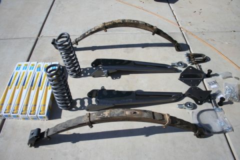 1989 Ford Bronco - Various vehicle suspension components are laid out on a concrete surface.