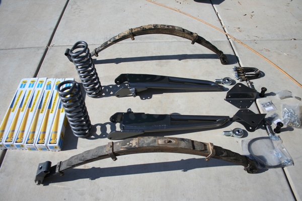 Suspension parts including leaf springs, coil springs, and shock absorber boxes on concrete