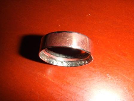 1996 Ford Bronco - A close-up view of a metal ring with visible markings on its inner surface, placed on a red background.