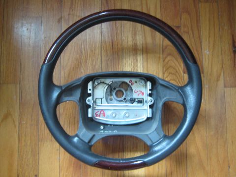 1993 Ford Probe - A steering wheel with wood trim and visible internal components is shown against a wooden background.