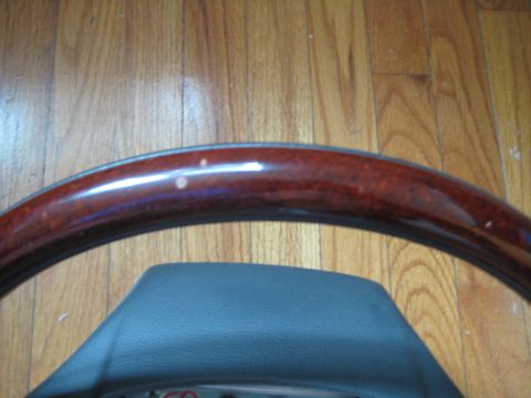 1993 Ford Probe - Close-up of a wood-trimmed steering wheel with a leather center section on a wooden floor.