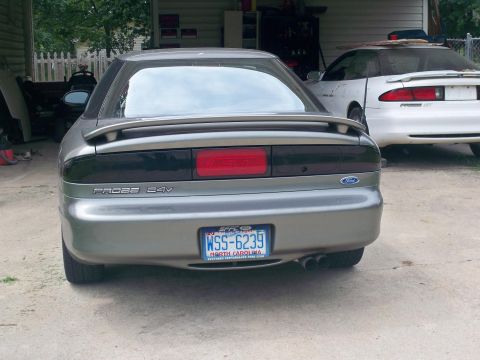 1995 Ford Probe - Two Ford Probes are parked in a driveway, one silver and one white.