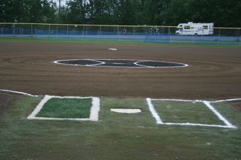 1990 Chevrolet Suburban - An RV motorhome is visible behind the outfield fence of a baseball field.