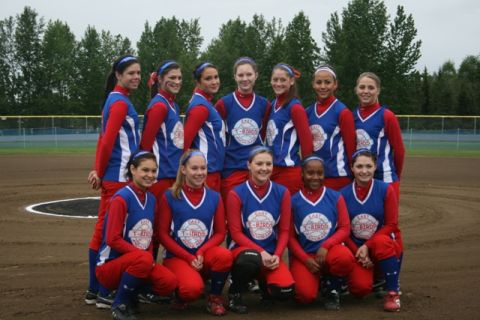 1990 Chevrolet Suburban - A group of young women in matching uniforms pose for a team photo on a baseball field.