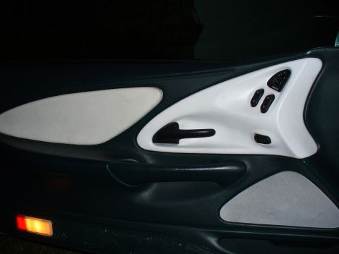 1995 Ford Thunderbird - Driver's side door panel interior, showing power window and lock controls.