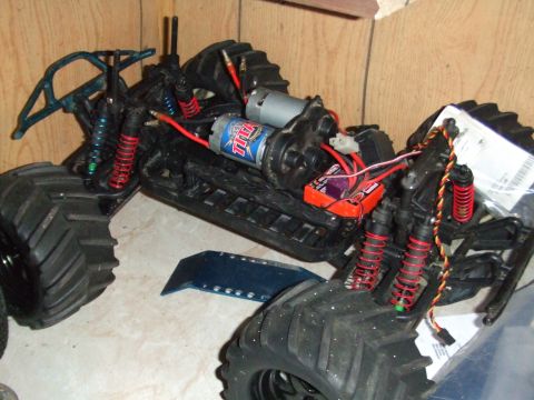 1996 Ford Bronco - Chassis of a remote control monster truck, showing motors, battery, and suspension components.