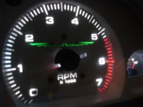 1995 Ford Thunderbird - Close-up of a car's illuminated tachometer gauge, showing RPM readings.