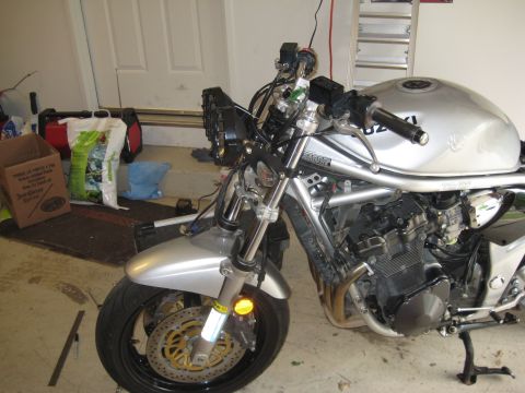 2003 Suzuki Bandit S - A silver motorcycle with a custom front end, dual headlights and an exposed engine, is shown in a garage setting.