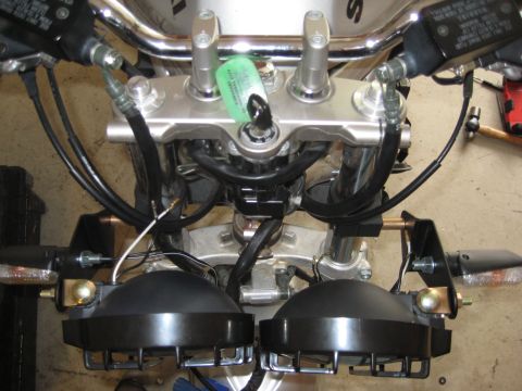 2003 Suzuki Bandit S - Close-up view of motorcycle handlebars, showing the ignition switch with a tag and dual front headlights.