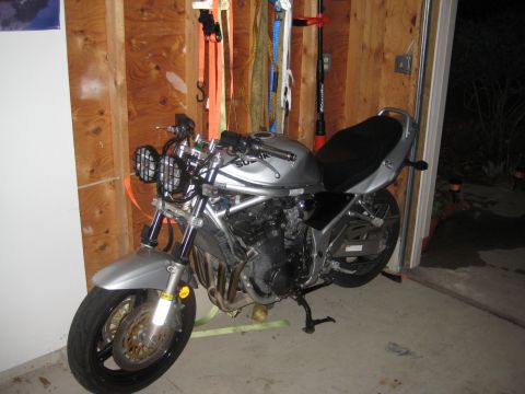 2003 Suzuki Bandit S - A silver 2003 Suzuki Bandit S motorcycle is parked inside a garage.