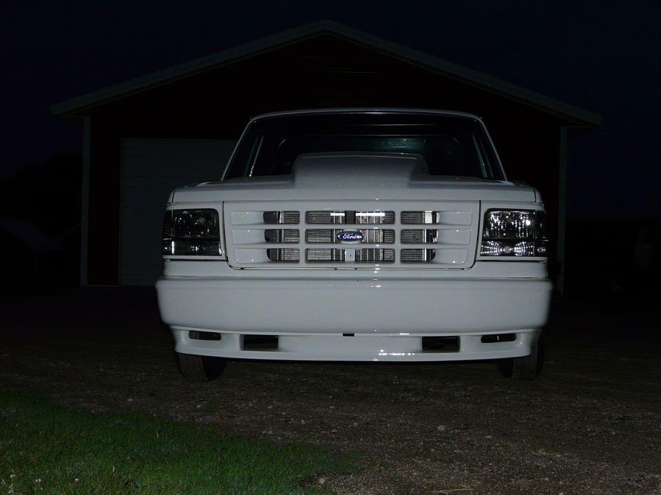 White Ford pickup front view at night with cowl hood and body-color bumper