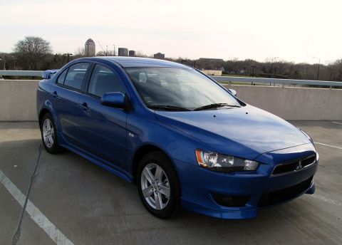2009 Mitsubishi Lancer - Front 3/4 view of a blue 2009 Mitsubishi Lancer sedan parked outdoors.