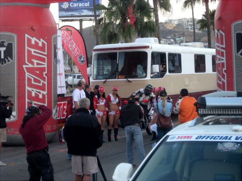 1996 Ford Bronco - A scene from a motorcycle race event, a bus, promotional banners, and participants.
