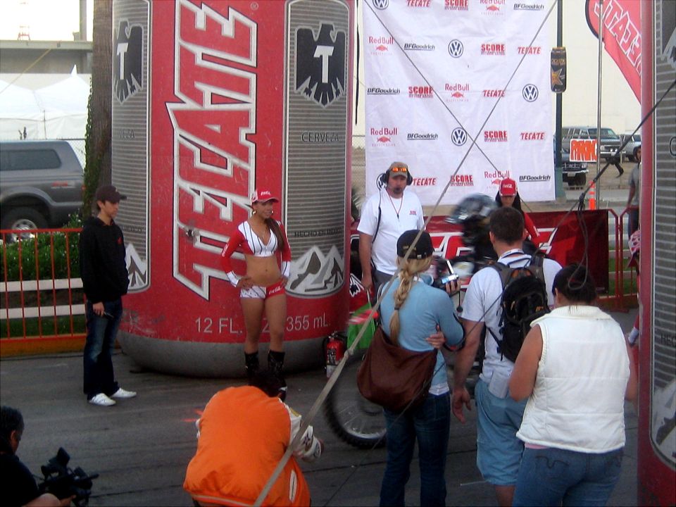 Large Tecate beer can display with people standing around it at an outdoor event