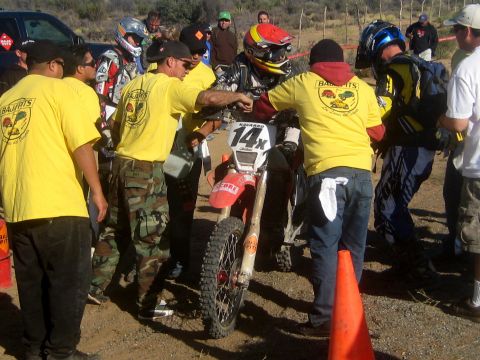 1996 Ford Bronco - Participants gather around a dirt bike, possibly before or after a race event.