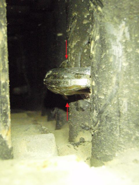1995 Ford Bronco - Close-up view of a tow point bolt, showing its connection point within a dirty vehicle frame.