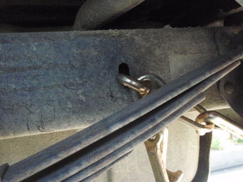 1995 Ford Bronco - Vehicle frame tow point with a chain and a wrench visible.