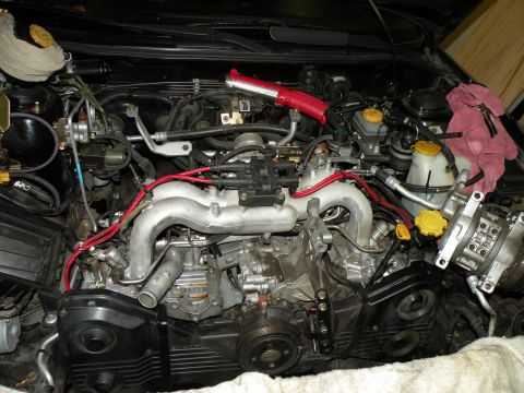 1998 Subaru Legacy - The engine bay of a Subaru is shown with the engine exposed and various components visible.