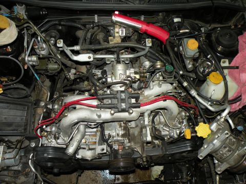 1998 Subaru Legacy - The engine bay is filled with various components and wiring, suggesting recent work or modifications.