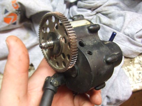 1996 Ford Bronco - Close-up of a toy bronco gearbox with a large metal gear, held by a hand.